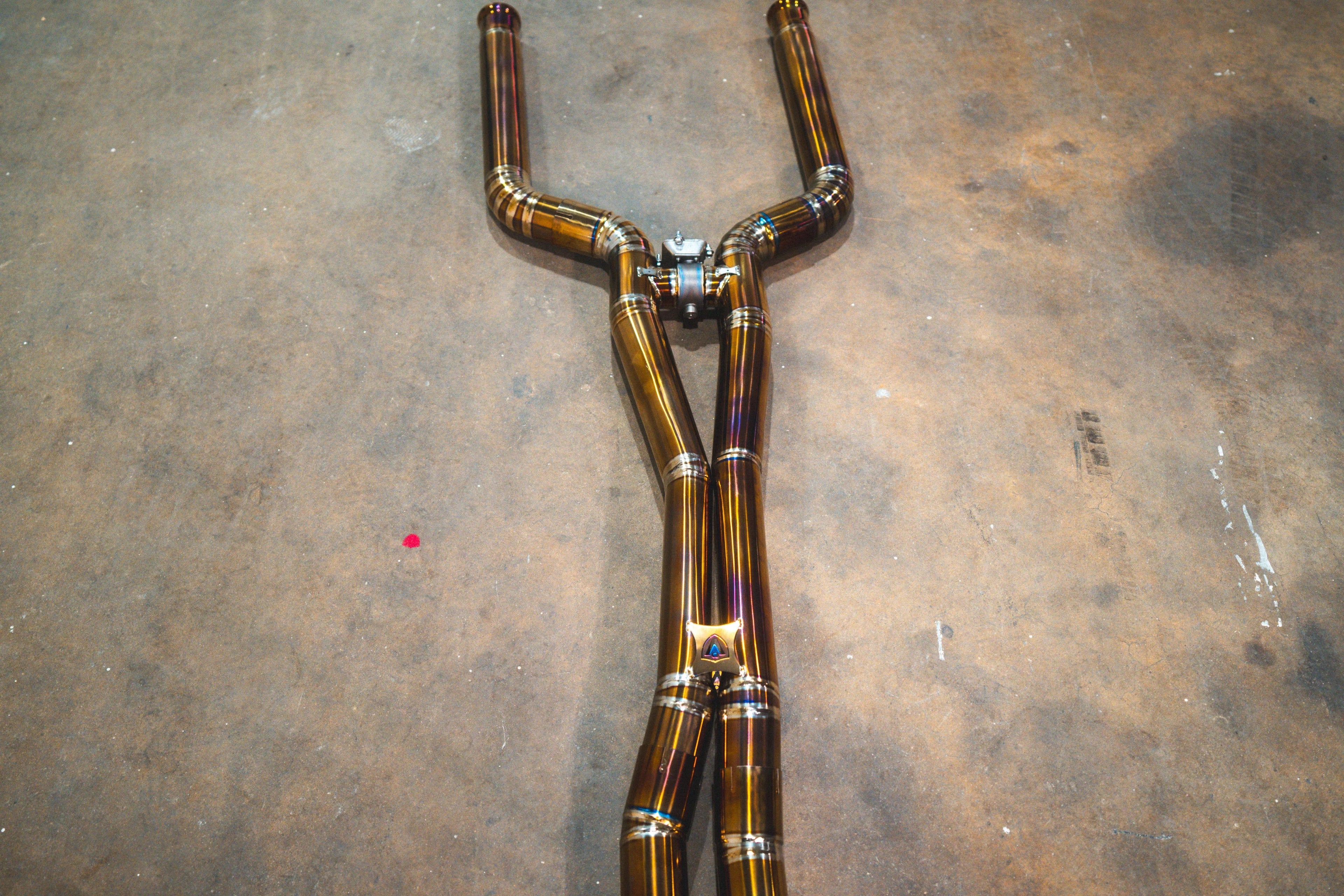 Close-up view of the center section of the exhaust system showing the X-pipe design and a Valvetronic logo badge.