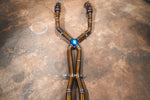 Detailed view of a titanium X-pipe mid-section with heat-tinted blue welds and integrated mounting brackets.