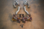 A top-down view of the complete exhaust assembly including gold-finish valved mufflers, silver heat-shielded front pipes, and long-tube headers.