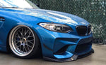 A side close up view of AUTOTECKNIC FRONT BUMPER DRY CARBON CANARD SET - BMW F87 M2 | M2 Competition 2016+ fitted on a blue car