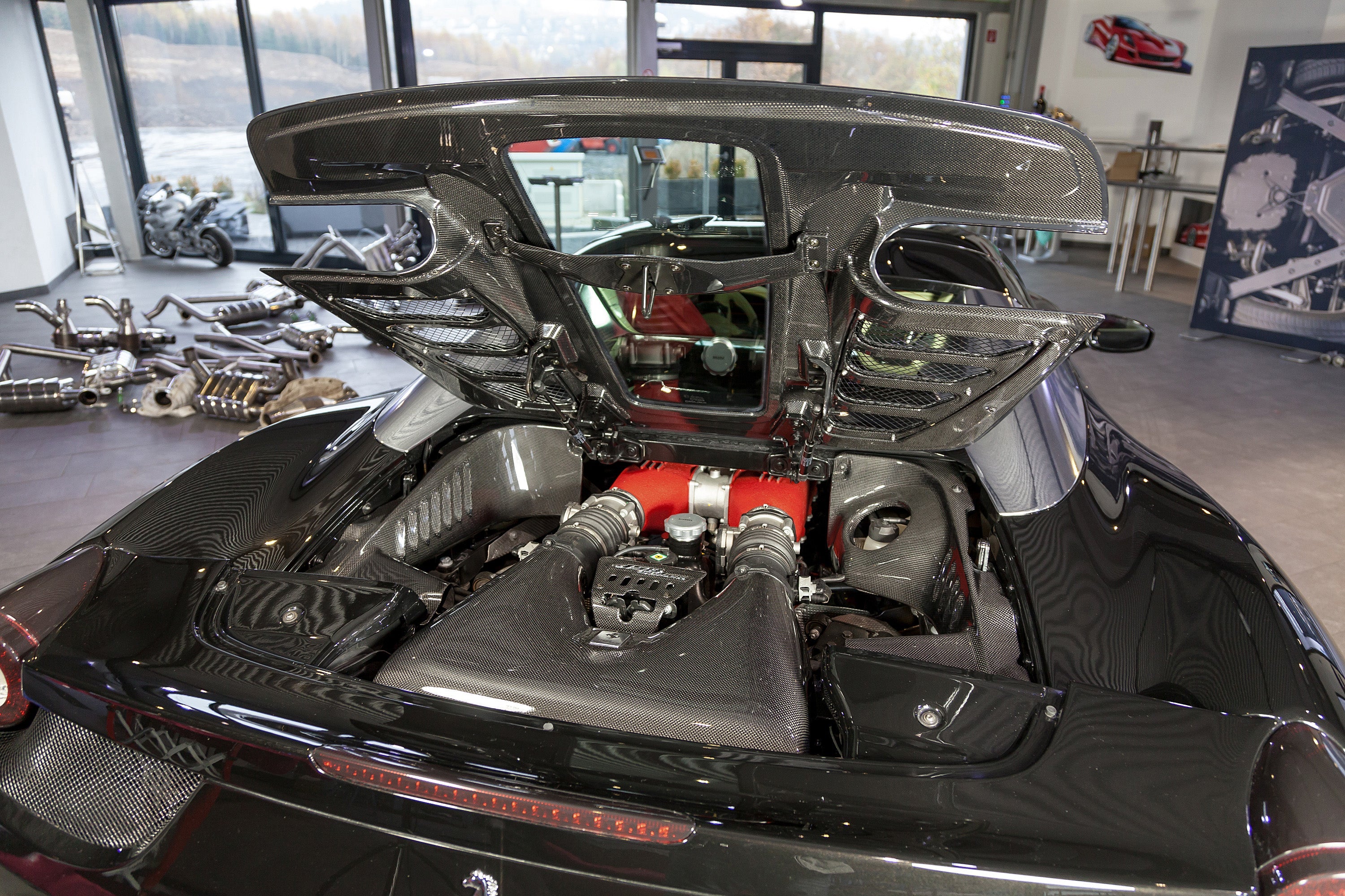 Capristo carbon fiber and glass bonnet on a black Ferrari 458 Spider, raised