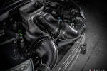 Carbon fiber intake system with curved tubes installed in engine bay with visible airbox and engine components - Eventuri intake for Porsche 911