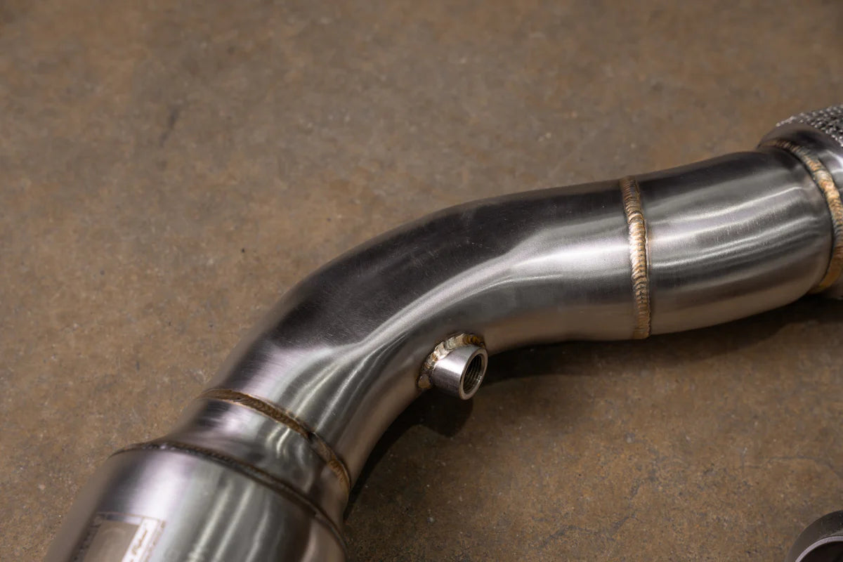 A close-up shot focusing on the mid-section of a Valvetronic Designs 400 Cell Catted Downpipe. 