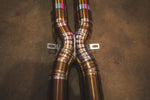 A detailed shot of the exhaust system's X-pipe merge point, showing the precision weld beads on the titanium piping.