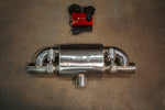 A single stainless steel t style muffler with dual valve actuators positioned horizontally below a red electronic control box and coiled wiring.