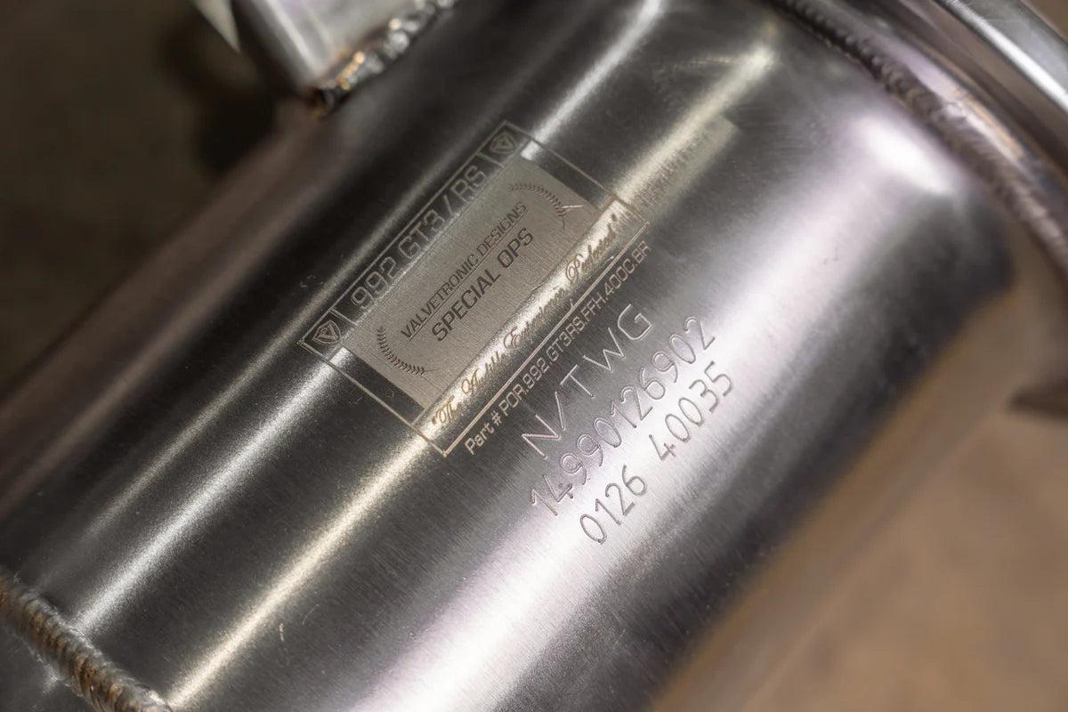 Detail view of Valvetronic Designs EPA-compliant 400-cell high-flow catalytic converter for Porsche 992 GT3/RS, showing authentic laser etching.