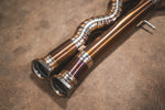 Close-up of the rear section of the titanium exhaust system showing the muffler, valve controller, and quad burnt blue tips.