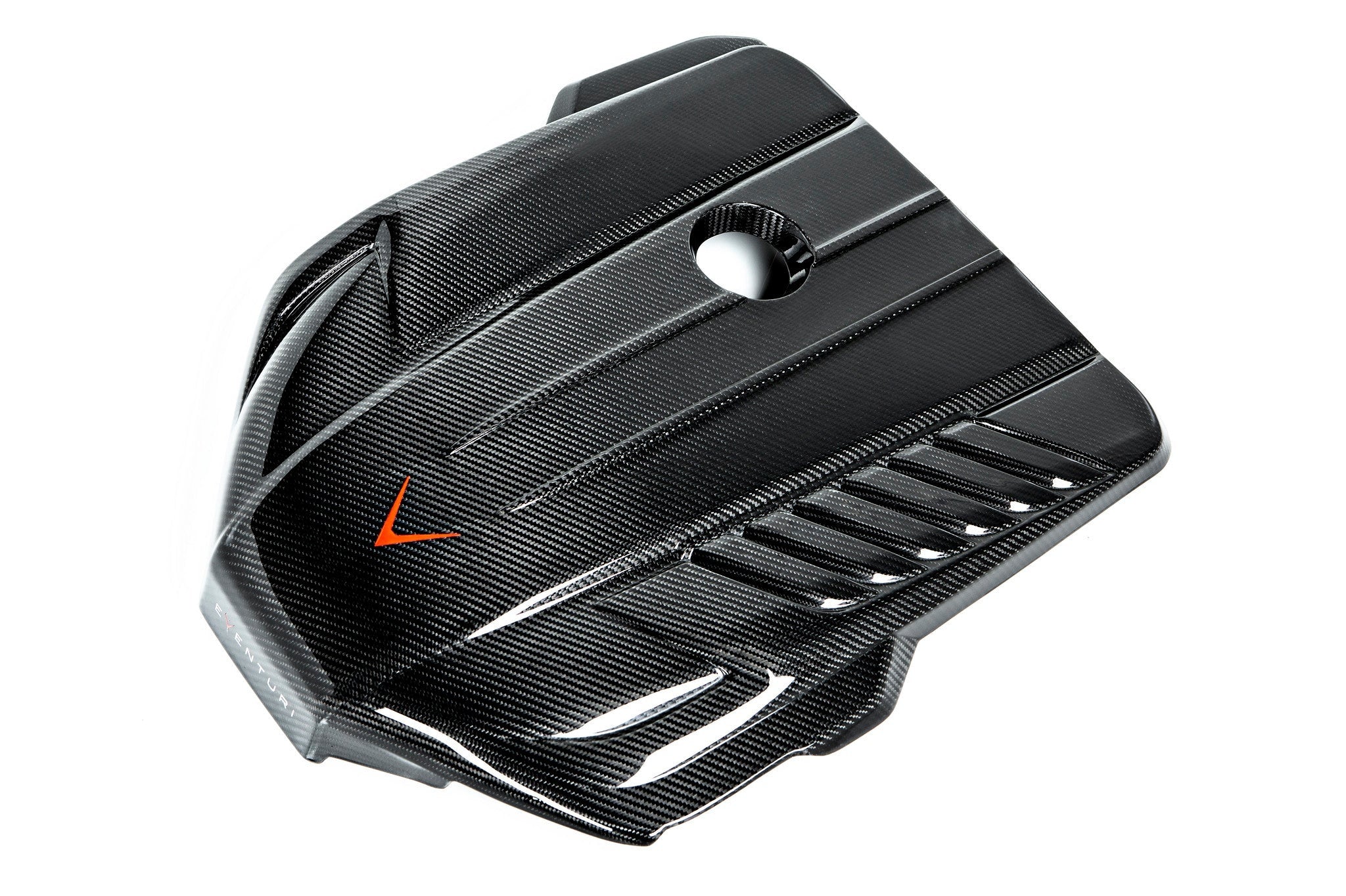 Black carbon fiber engine cover with geometric angular design, central circular opening, and side ventilation slats - Eventuri engine cover for Toyota Supra