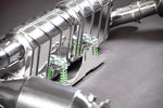 Close-up of polished muffler and green-spring valves on Capristo Porsche 997 Turbo exhaust