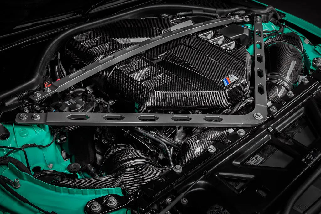 Wide view of a mint green G8X S58 engine bay with the Eventuri carbon cover and strut brace