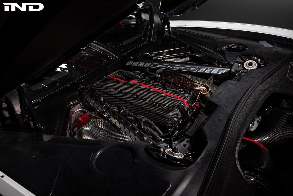 Black carbon fiber engine cover with red trim accents installed in Corvette engine bay - Eventuri engine cover for Chevrolet Corvette