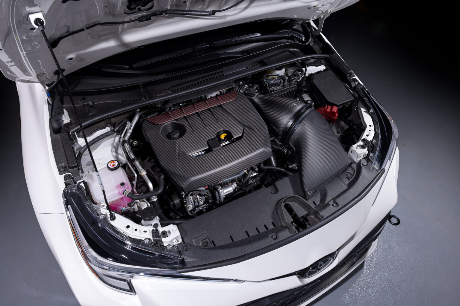 Eventuri carbon intake fitted in a white GR Corolla, seen from the driver side