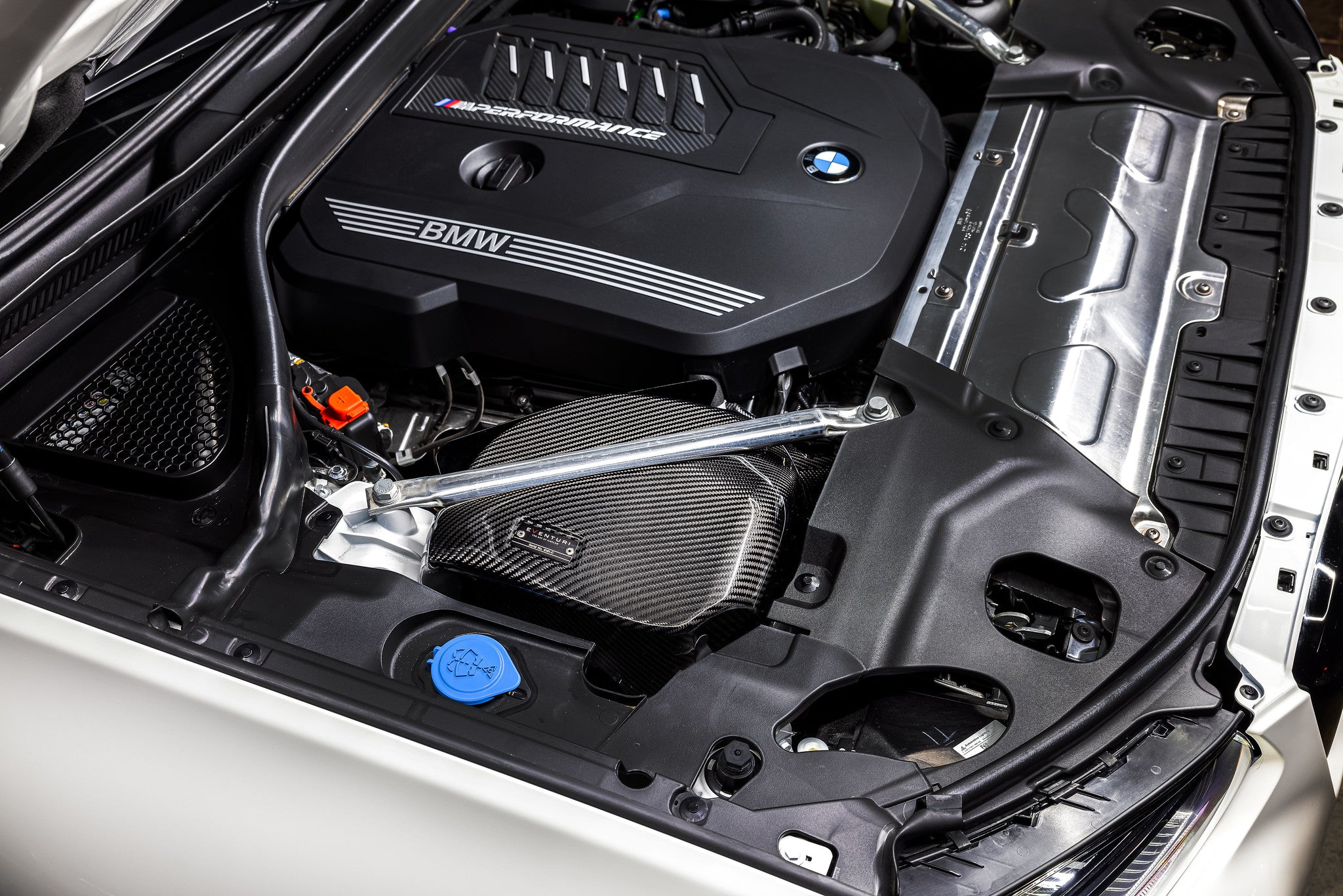 A close up view of a white car with its bonnet open fitted with Eventuri Carbon Intake System BMW G01 X3 / G02 X4 M40i (B58) 2018+ 