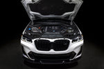 A front view of a white car with its bonnet open fitted with Eventuri Carbon Intake System BMW G01 X3 / G02 X4 M40i (B58) 2018+ with black background
