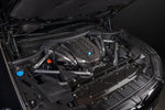 Carbon fiber engine cover and intake components installed in BMW engine bay with hood open - Eventuri intake for BMW X5 M50i