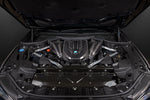 Carbon fiber intake system installed in engine bay with curved tubes and central airbox assembly - Eventuri intake for BMW X5 M50i