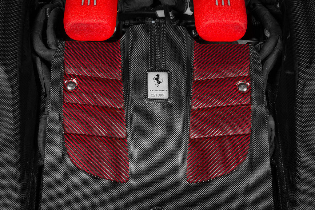 A close up view of Eventuri Carbon Intake System for Ferrari F12 Berlinetta 2012-2017 fitted inside a red car on a black background