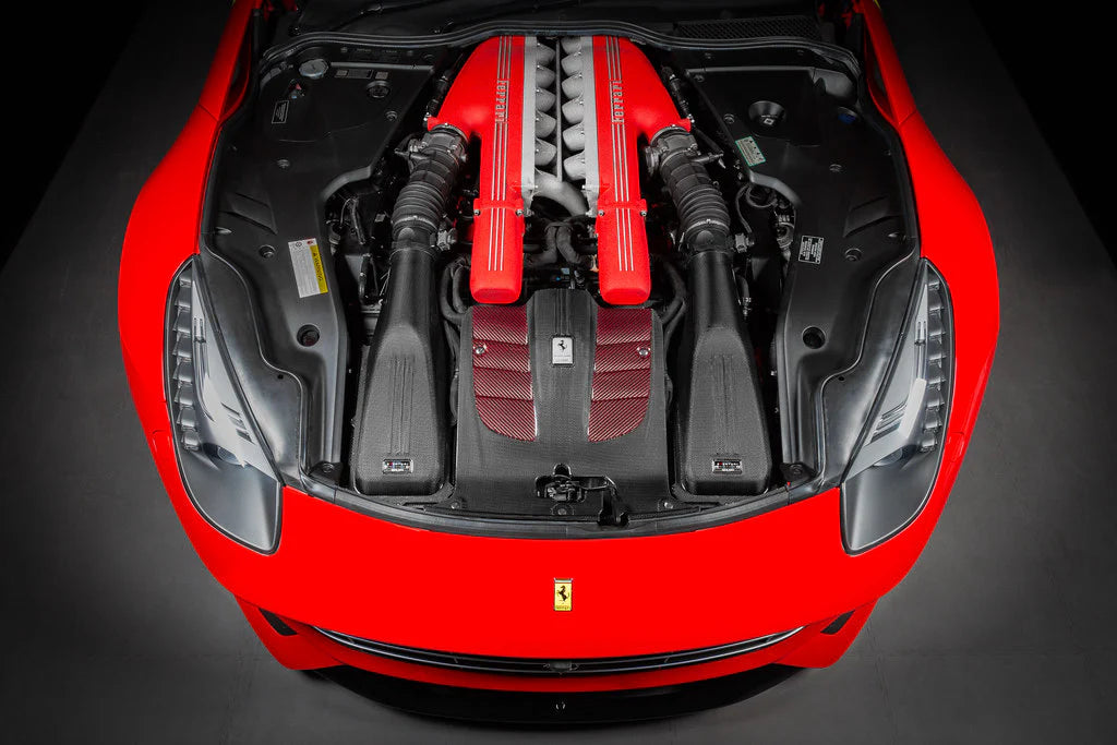 A top wide view of Eventuri Carbon Intake System for Ferrari F12 Berlinetta 2012-2017 fitted inside a red car on a black background
