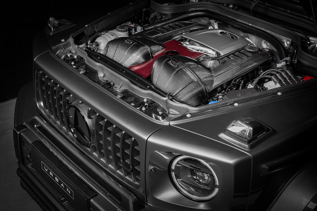Black carbon fiber intake system with red filter installed in Mercedes G63 engine bay with hood open - Eventuri cold air intake for Mercedes-Benz G63 AMG