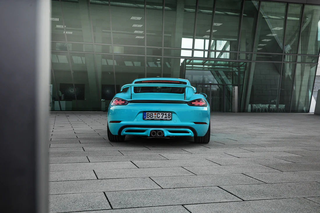 A wide back view of TECHART Rear Spoiler II for Porsche 718 Cayman fitted on a blue car