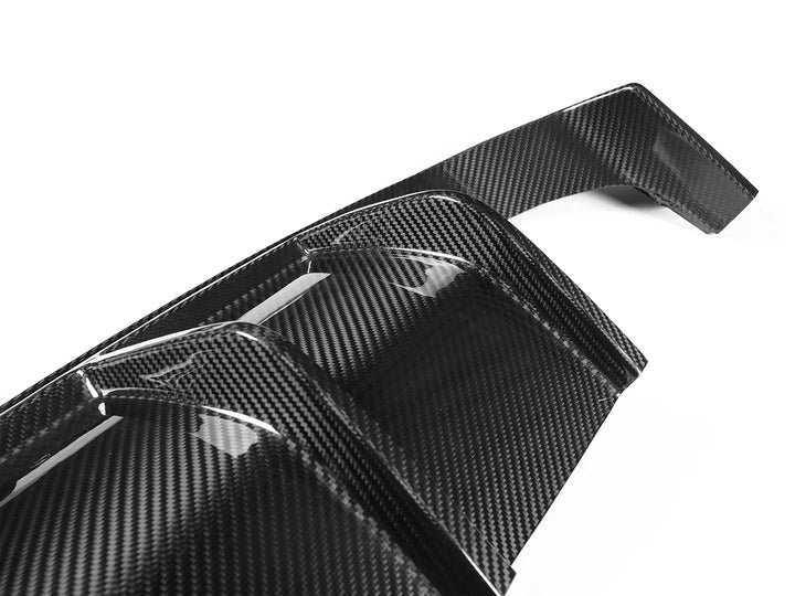 A close up view of AUTOTECKNIC DRY CARBON VERSUS REAR DIFFUSER SET - BMW F80 M3 | F82/ F83 M4 2014+ with white background