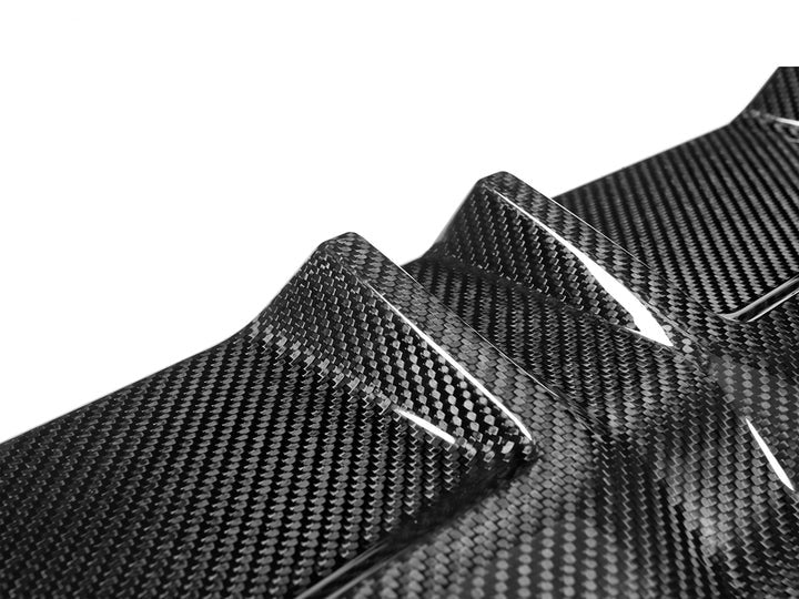 A close up view of AUTOTECKNIC DRY CARBON PERFORMANTE REAR DIFFUSER - BMW G42 2-SERIES M-SPORT 2022+ with white background