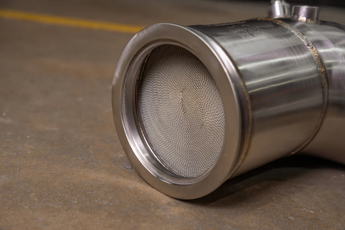 Close-up of Valvetronic Designs Audi C8 RS6/RS7 catted downpipe showing the 400-cell metallic honeycomb substrate and precision-machined V-band flange.