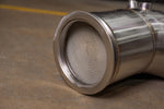 Close-up of Valvetronic Designs Audi C8 RS6/RS7 catted downpipe showing the 400-cell metallic honeycomb substrate and precision-machined V-band flange.