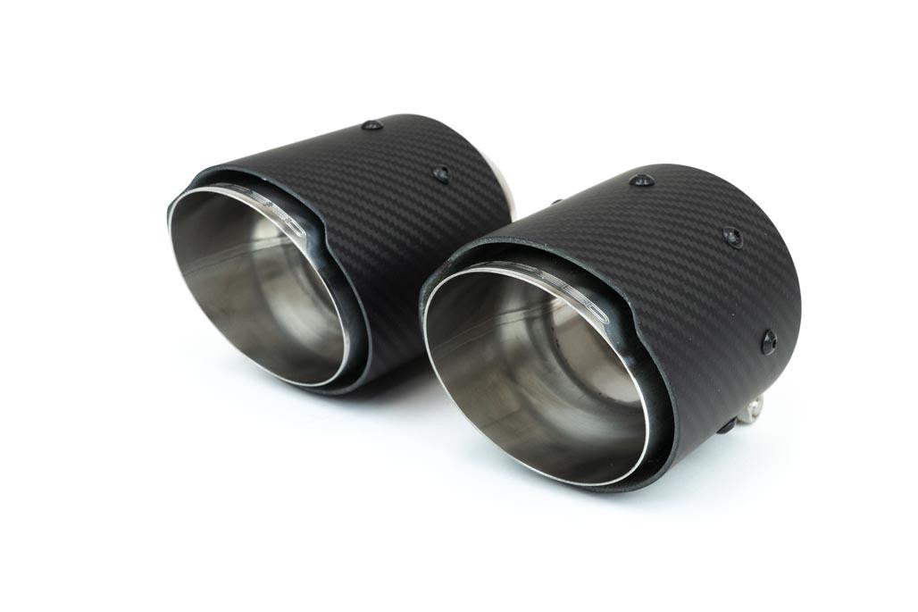 Close-up of a pair of carbon fiber shrouded exhaust tips featuring a stainless steel inner liner and the Fabspeed logo.