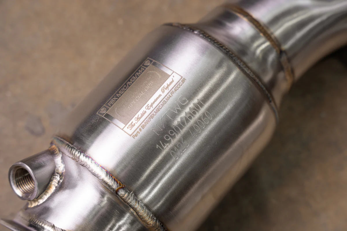 A close-up of the Valvetronic Designs 400 Cell Catted Downpipe focusing on the laser-etched identification plate on the brushed T304 stainless steel body.