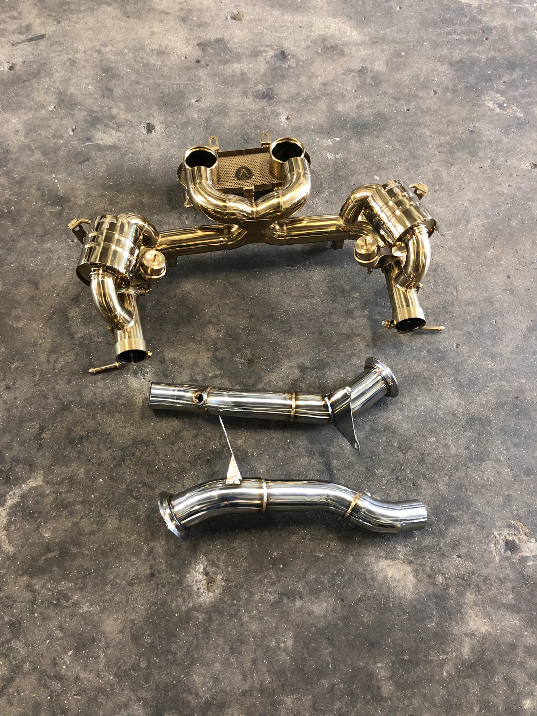 A wide overview of Valvetronic Designs Valved Sport Exhaust System with free flow front pipes on the ground (for Ferrari 458 Italia).