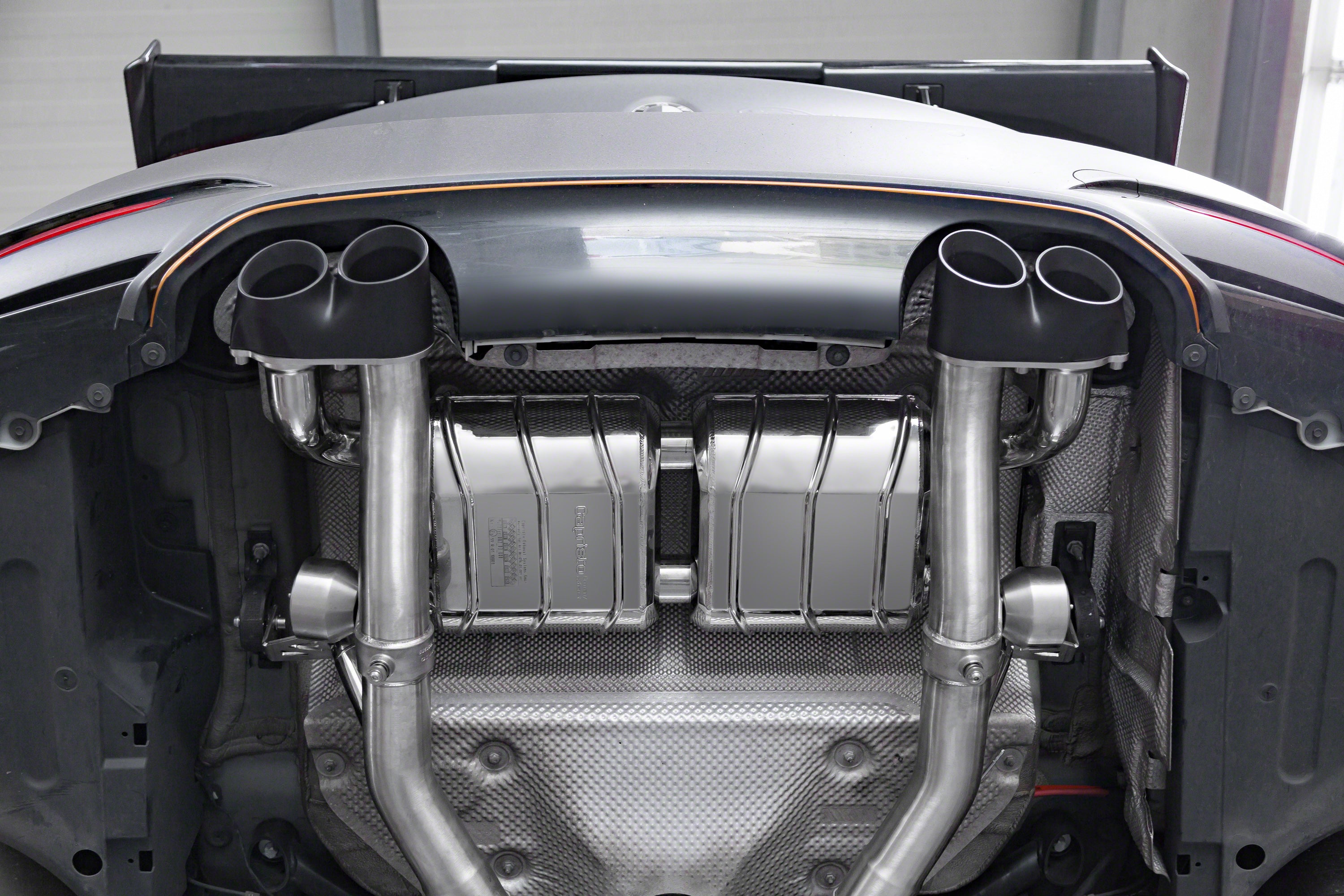 Close-up of Capristo black ceramic quad tips installed on a BMW M4