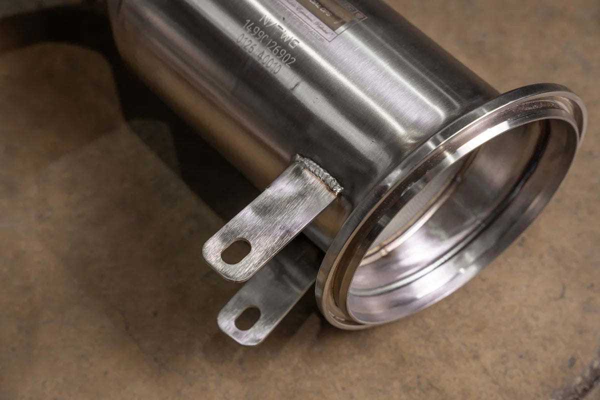 Close-up of V-band flange and TIG-welded mounting brackets on Valvetronic Designs Porsche 992 GT3 high-flow downpipes.