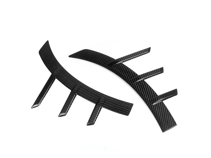 A front view of AUTOTECKNIC DRY CARBON FRONT FENDER ARCH TRIM SET - BMW G87 M2 2023+ with white background