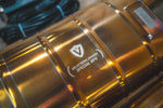 Macro shot of the "Valvetronic Designs Special Ops" branding and serial number plate on the polished gold-finish muffler body.