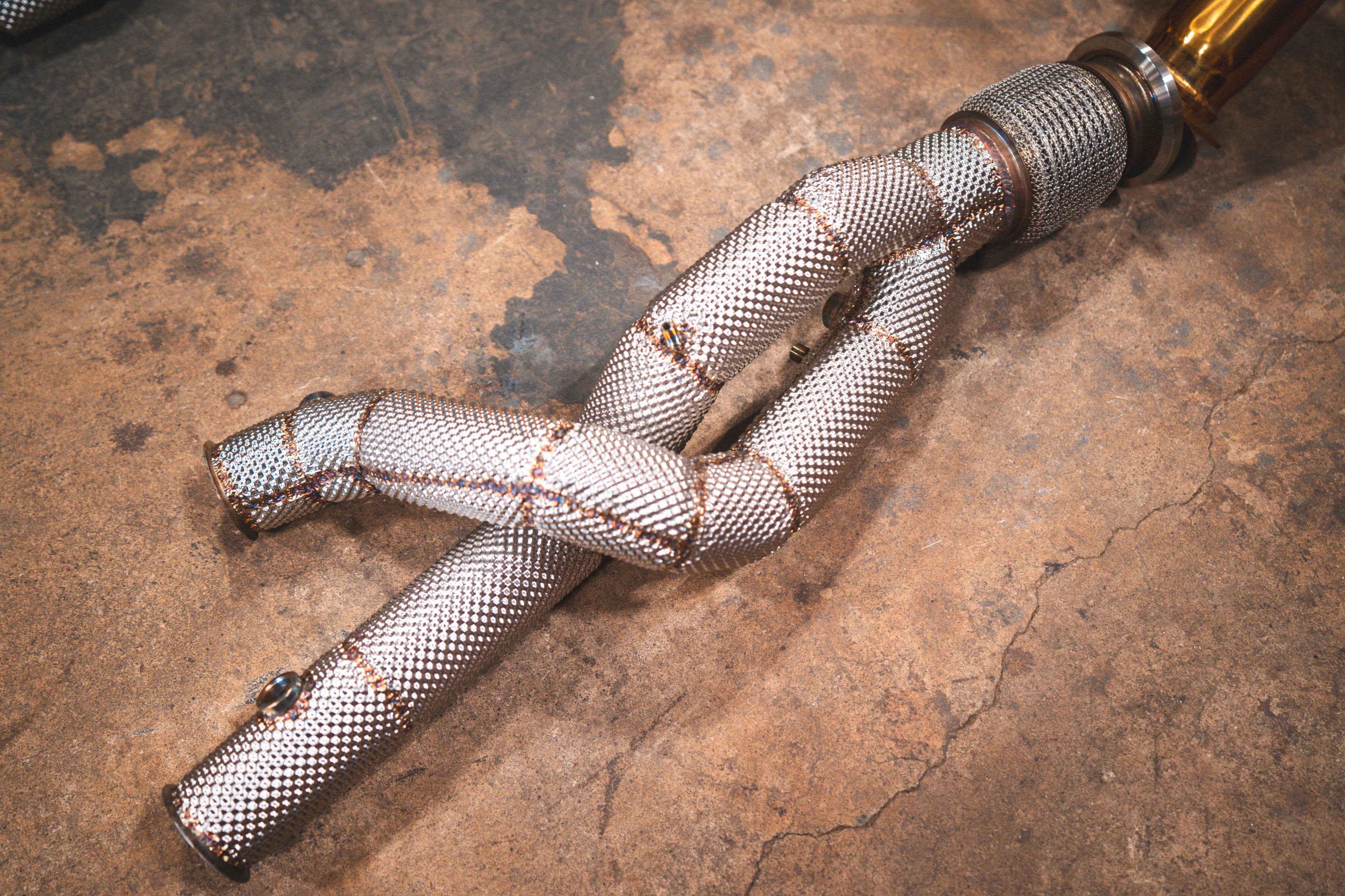 Detailed close-up of the silver braided heat shielding wrapped around a section of the exhaust piping.