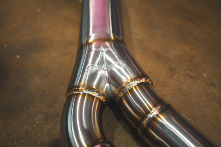 BMW G30 530i Valvetronic exhaust: Y-pipe junction with heat tint, close-up