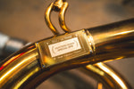 Extreme close-up of a gold-plated plaque welded to the exhaust pipe labeled "SVJ / ULTIMAE" and "Valvetronic Designs Special Ops."
