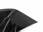 A close up view of AUTOTECKNIC DRY CARBON CORSA FRONT AIR INLET TRIM SET - BMW G87 M2 2023+ with white background