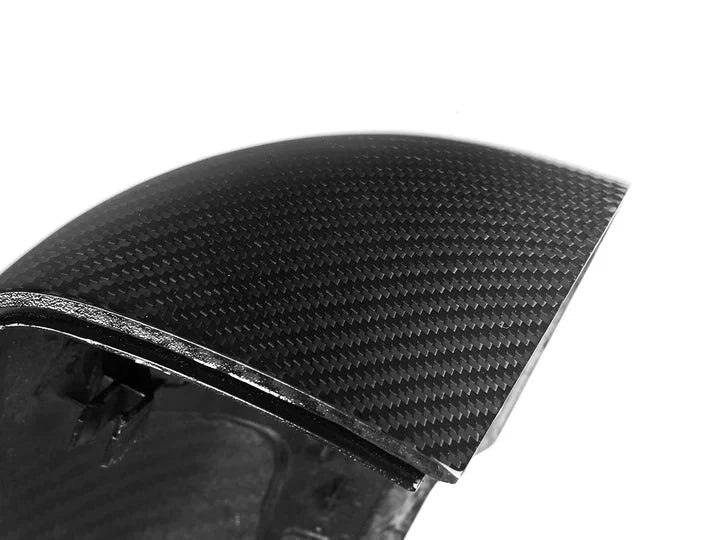 A close up view of AUTOTECKNIC DRY CARBON FIBER MIRROR COVER SET - BMW U11 X1 2023+ with white background
