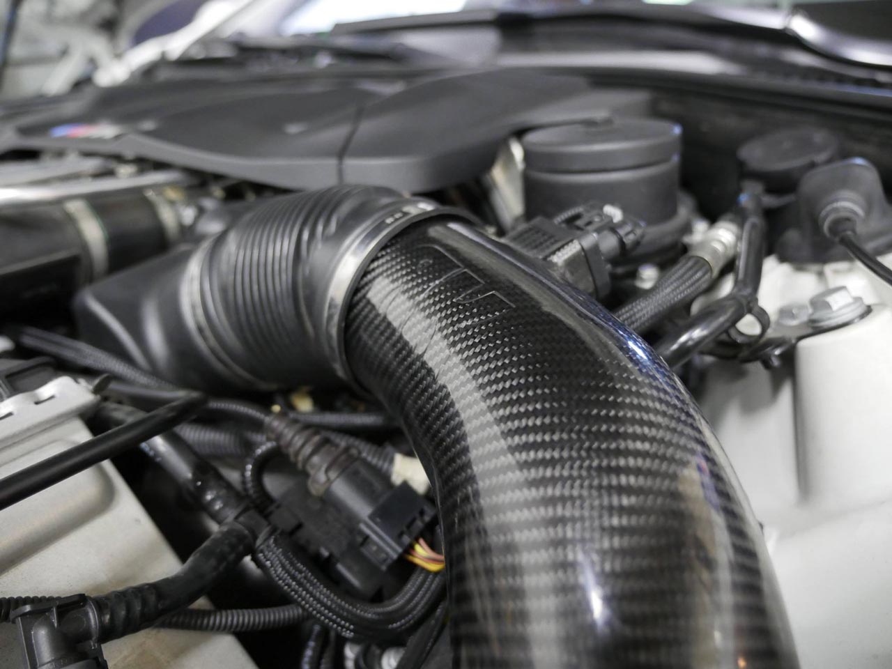 A close up view of RK Autowerks F1X M5 M6 CARBON FIBER INTAKES fitted on a car