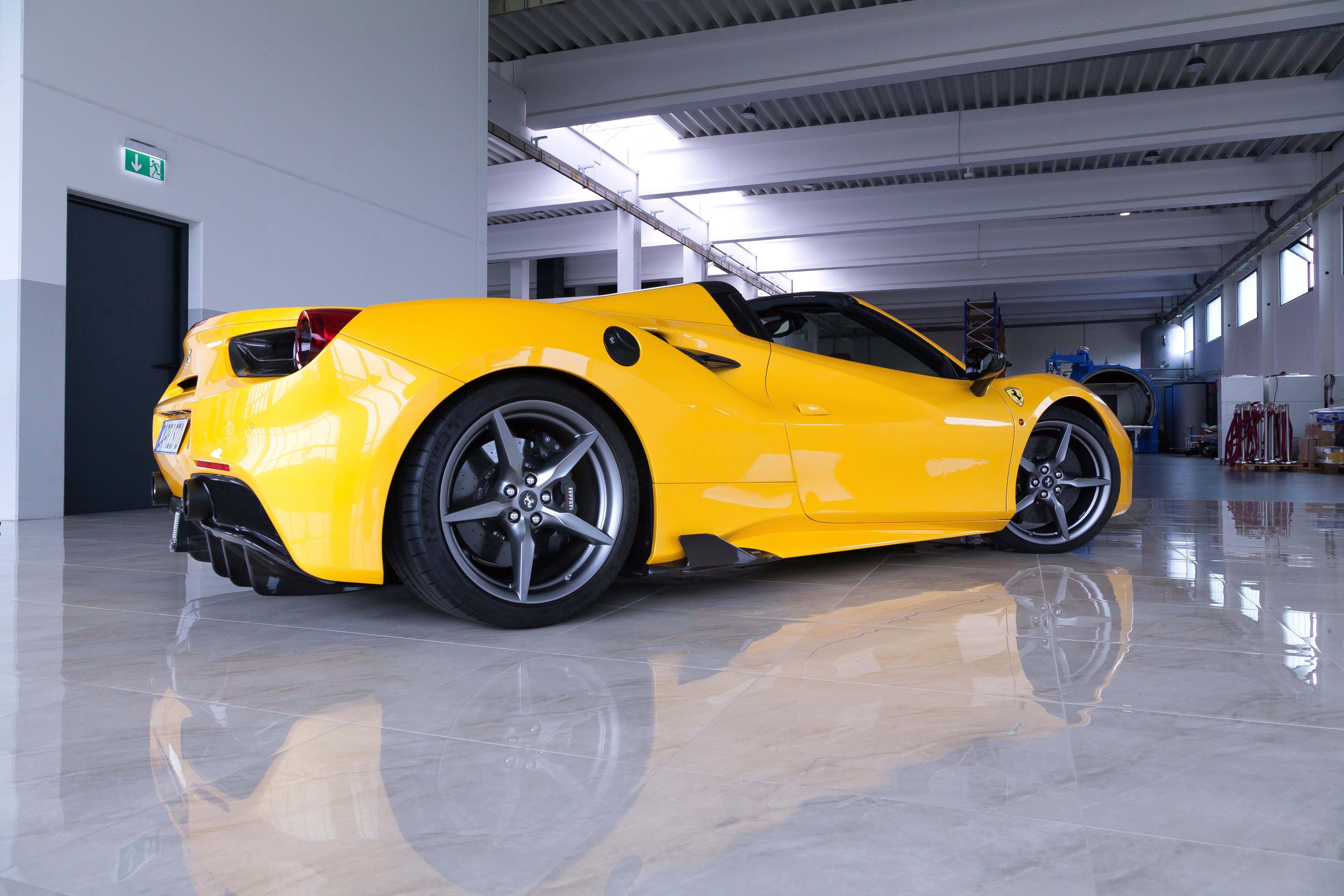 Yellow Ferrari 488 Spider with Capristo carbon side fins, rear quarter view