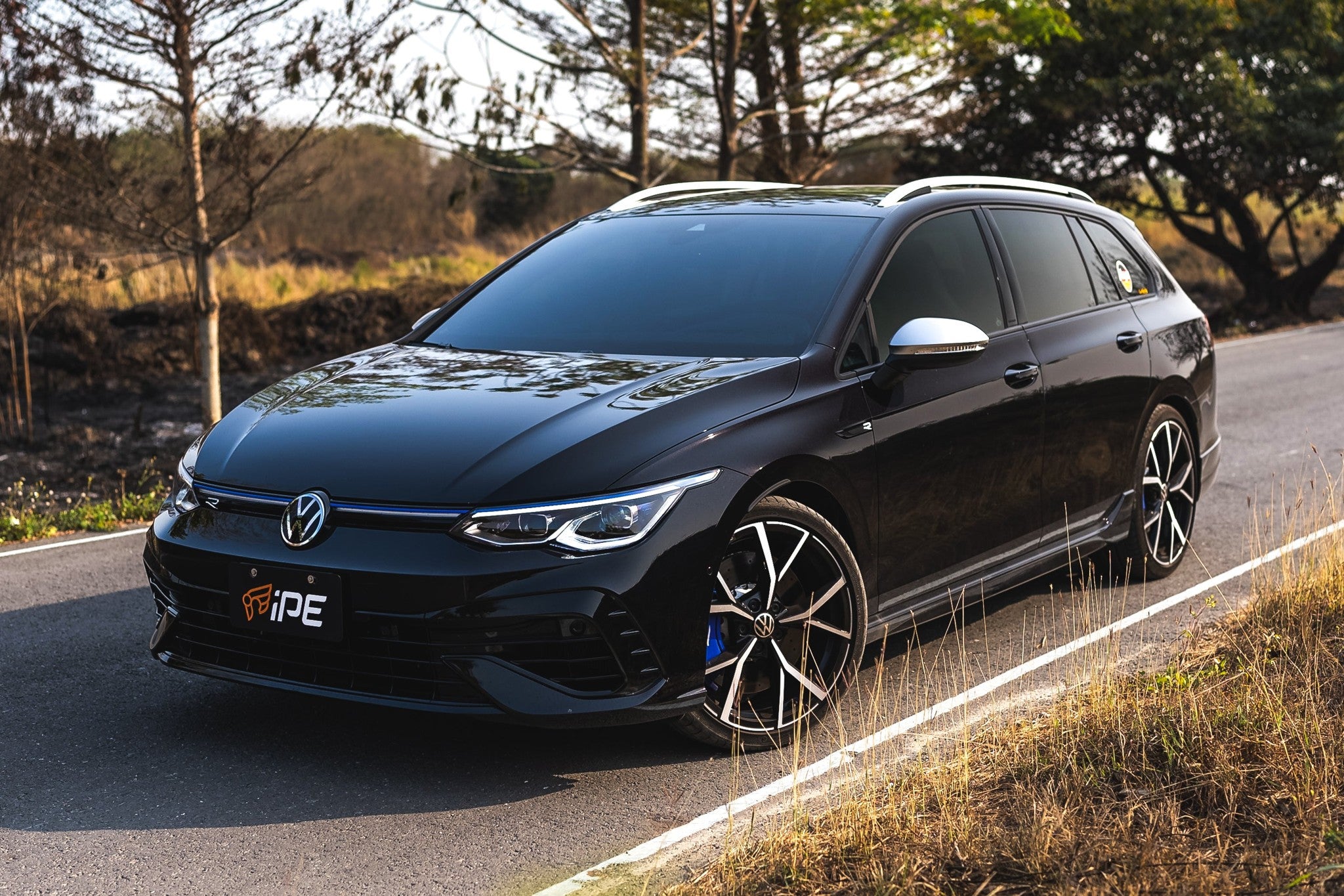 Black Volkswagen Golf R Variant Mk8 wagon on a country road