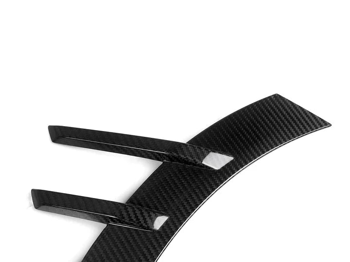 A close up view of AUTOTECKNIC DRY CARBON FRONT FENDER ARCH TRIM SET - BMW G87 M2 2023+ with white background