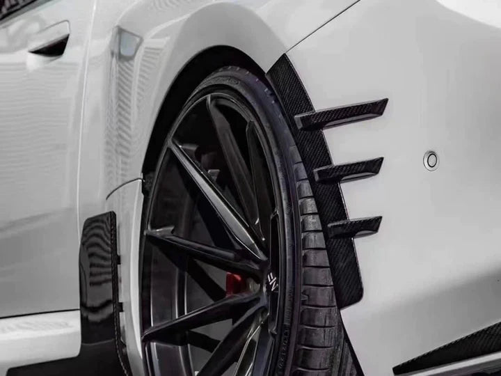 A close up view of AUTOTECKNIC DRY CARBON REAR FENDER ARCH TRIM SET - BMW G87 M2 2023+ fitted on a car