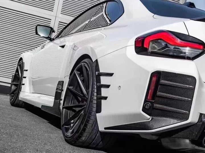 A back view of AUTOTECKNIC DRY CARBON REAR BUMPER TRIM SET - BMW G87 M2 2023+ fitted on a car