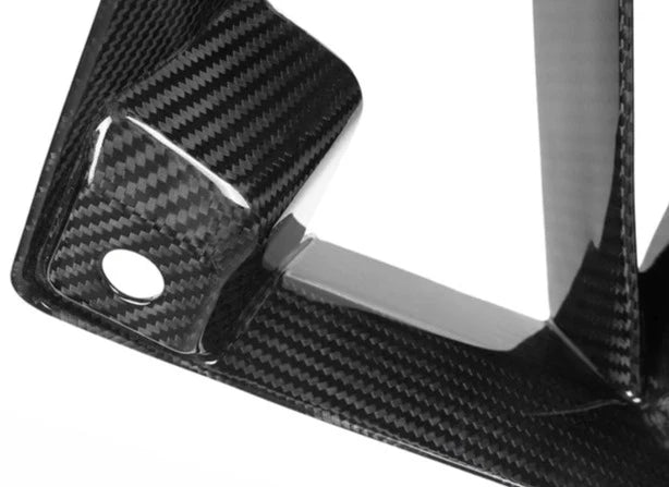 A close up view of AUTOTECKNIC DRY CARBON FRONT AIR INLET TRIM SET - BMW G87 M2 2023+ with white background