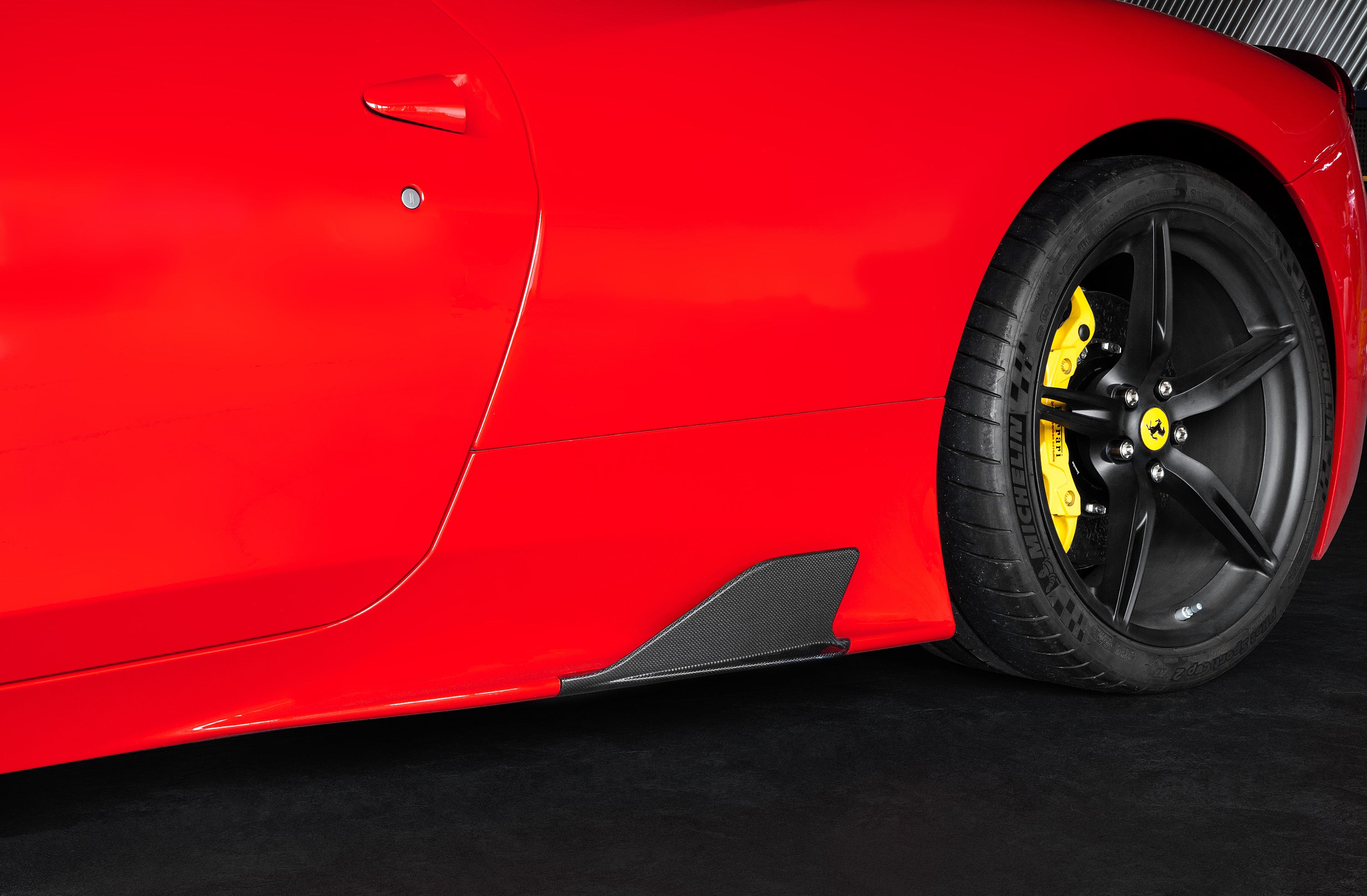 Capristo carbon fiber side fin on a red Ferrari 458 Speciale behind the front wheel