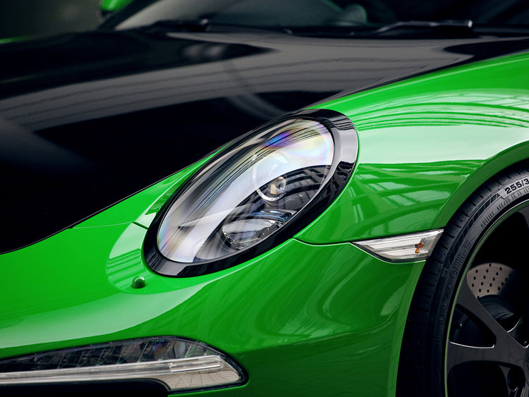 A close up view of TECHART Headlight Trim Porsche 991 Carrera / Targa / Turbo / GT3 fitted on a green car