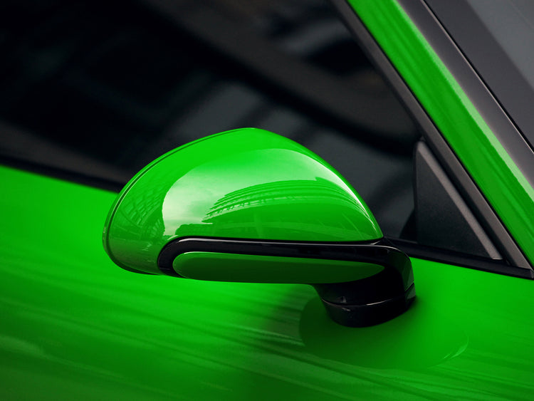 A close up view of TECHART Side Mirror Trims 991 Carrera / Targa / Turbo / GT3 fitted on a green car